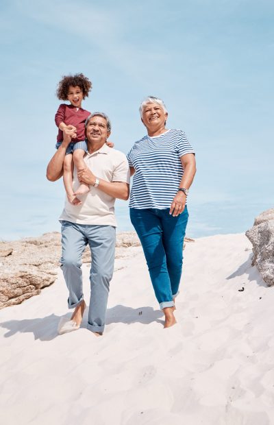 Shot of an adorable little boy at the beach with his grandparents.